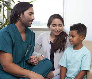 Healthcare provider talking to woman and boy.