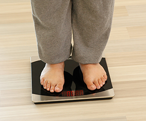 Closeup of woman's feet on bathroom scale.