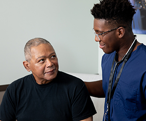 Healthcare provider talking to man in exam room.