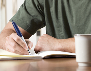 Hombre escribiendo en un diario.