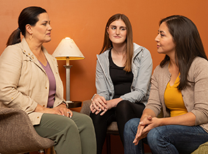 Tres mujeres en un grupo de apoyo.