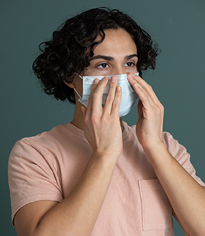 Un hombre se coloca una mascarilla médica.