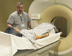 Technician preparing woman for CT scan.